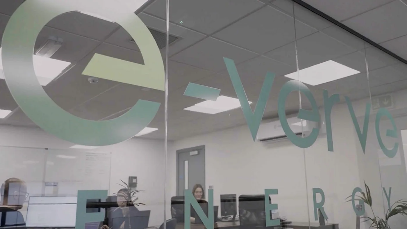 Inside the E-Verve Energy office, branded glass with the team at work
