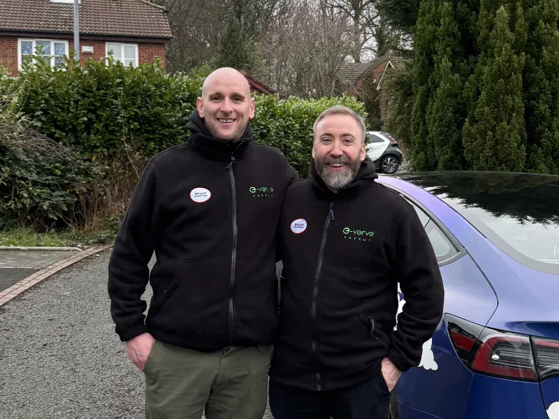 The E-Verve Energy team in branded fleeces beside the company car